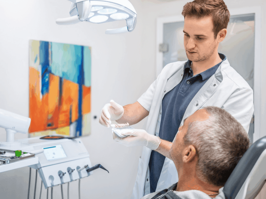 Zahntechniker bei der Farbestimmung mit Patient.