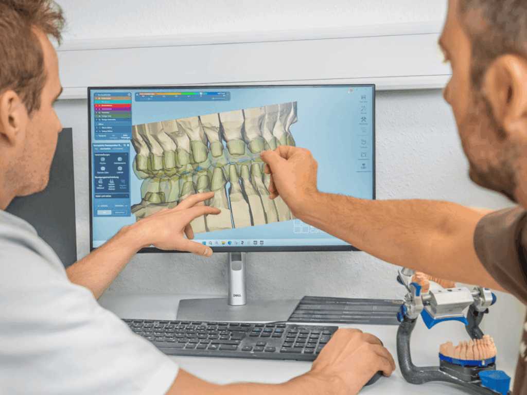 Zahnarzt Dr. Henninger bespricht die Planung von Implantaten mit dem Zahntechniker im hauseigenen Labor.